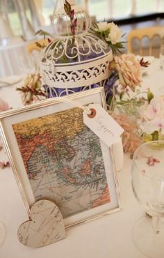 the table is set with an old world map and place cards for guests to sign