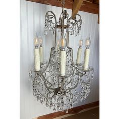 a chandelier hanging from the ceiling in a room with wood paneling and white walls