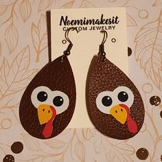 a pair of brown earrings with a turkey face on the front and back of it