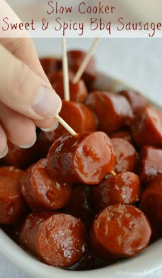 a person is dipping some food into a bowl with toothpicks in it and the words slow cooker sweet & spicy bbq sausage