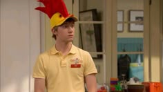 the young man is dressed as a chicken on his head and wearing a yellow shirt