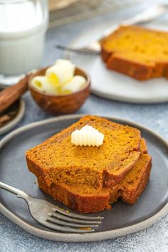 two slices of pumpkin bread on a plate with a fork and glass of milk in the background