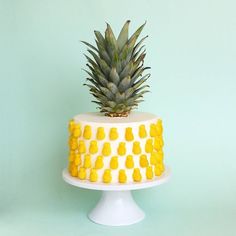 a pineapple sits on top of a white cake