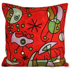 a red pillow with abstract designs on it