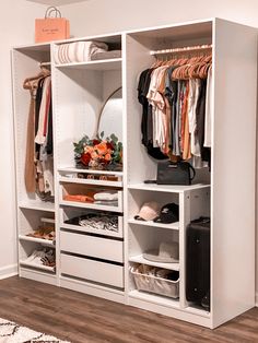 an organized closet with clothes and suitcases on the shelves, along with other items