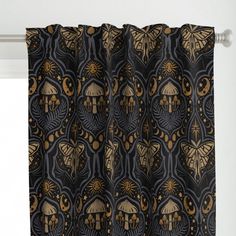 a curtain with an intricate design in gold and black, hanging on a white wall