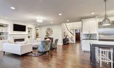 a living room filled with furniture and a flat screen tv mounted to the wall above a fireplace