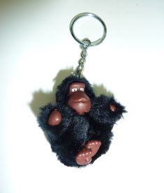 a stuffed gorilla keychain hanging on a white wall