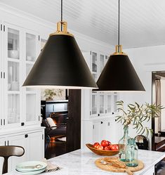 two black lamps hanging over a kitchen island