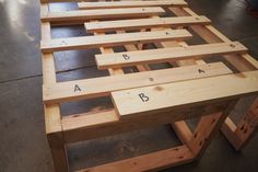 a table made out of wooden planks with letters and numbers on the top part