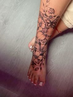 a woman's foot with flowers on it and the bottom part of her leg