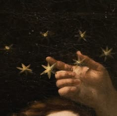 a close up of a person's hand holding stars