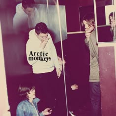 two young men standing in front of a mirror