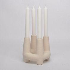 four white candles are placed in the shape of an animal's head and legs