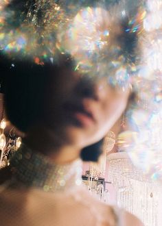 a woman is standing in front of a christmas tree with many lights on her head