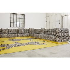 a leopard print couch sitting on top of a yellow rug