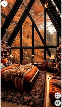 a bedroom with an orange bed in front of a large window that looks out onto the woods