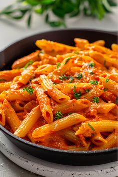 a pan filled with pasta and sauce on top of a table