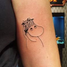 a woman's arm with a tattoo of a horse and flowers on her head