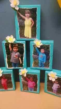 four small blue frames with pictures of children holding flowers on them, sitting on a table