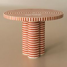 three red and white striped plates stacked on top of each other in front of a gray background