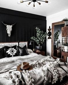 a black and white photo of a bedroom with a cow skull hanging on the wall