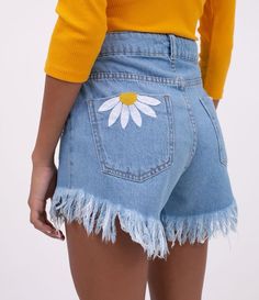 the back of a woman's jean shorts with daisy embroidered on it