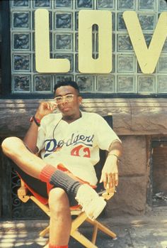 a man sitting in a chair next to a love sign