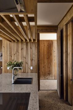 a kitchen with wood paneling and granite counter tops, along with an open door leading to another room