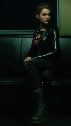 a woman sitting on top of a bench in a dark room with her legs crossed