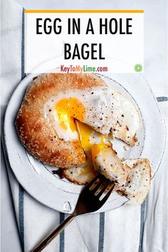 an egg in a hole bagel on a plate with a fork