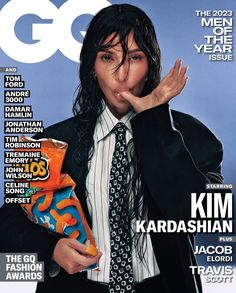 the cover of gq magazine features a man in a suit and tie with his hands up to his mouth