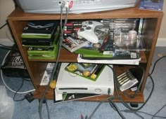 a bunch of electronic equipment sitting on top of a wooden shelf next to a computer monitor