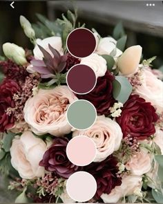 a wedding bouquet with flowers and greenery on the bottom, in shades of burgundy