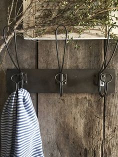 an old coat rack with two hooks and a towel hanging from it's side