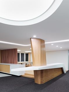 the interior of a modern office building with curved ceiling and white walls, carpeted flooring