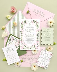 the wedding stationery is laid out on top of pink and green paper with flowers