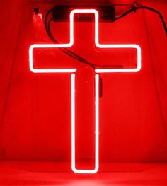 a red neon sign with a cross on it