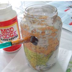 a jar filled with paint sitting on top of a table next to a bottle of glue