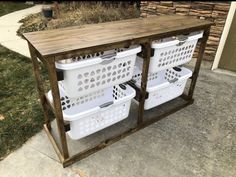 two white laundry baskets sitting on top of a wooden table