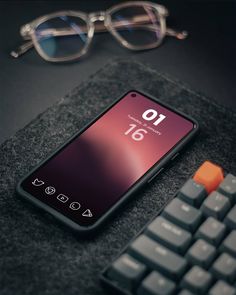 a cell phone sitting on top of a table next to a keyboard and eyeglasses