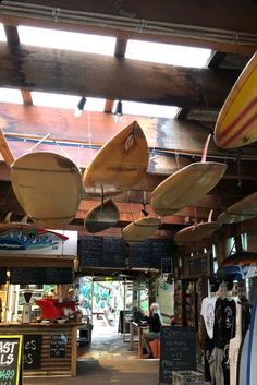 several surfboards hanging from the ceiling in a shop