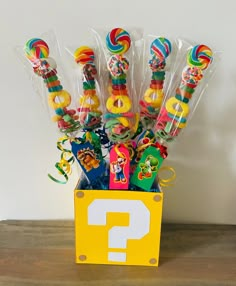 a box filled with candy and lollipops on top of a wooden table