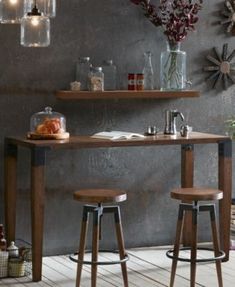 two stools in front of a table with vases and plants on it,