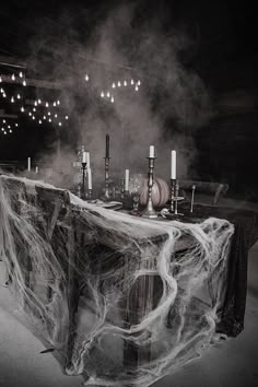 the table is covered with spider web and candles