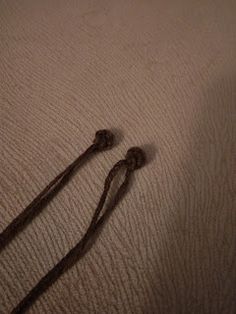 two brown cords laying on top of a bed