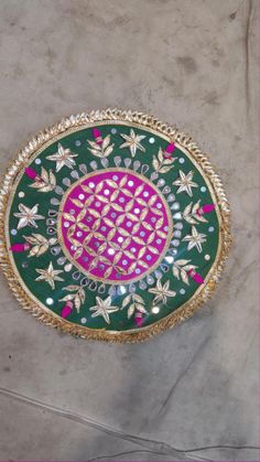 a green and pink plate sitting on top of a floor