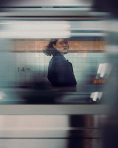 a blurry photo of a woman standing in front of a train