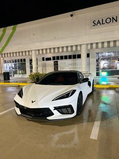 a white sports car parked in front of a salon