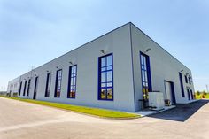 an industrial building with large windows and blue trim